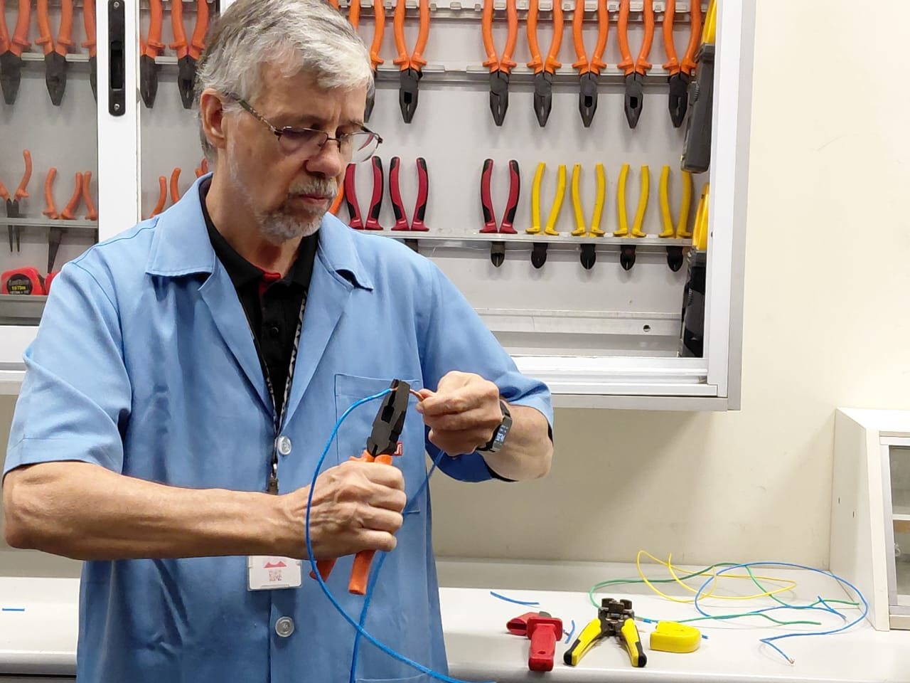 Instrutor demonstra técnica de instalação elétrica em curso de mão de obra qualificada da Emccamp no SENAI