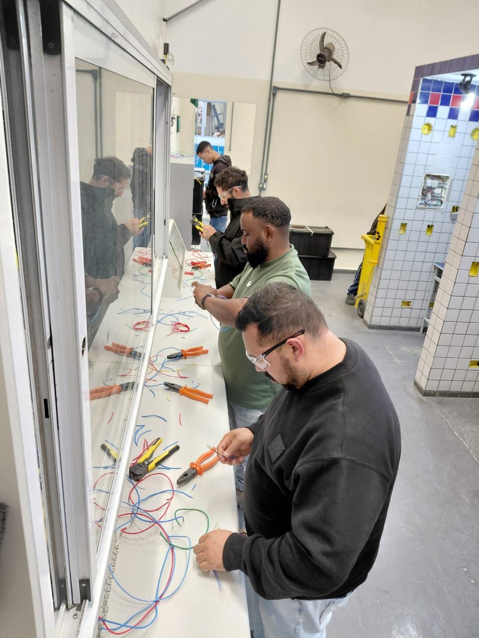 Colaborador pratica montagem de painel com eletrodutos em curso de mão de obra qualificada